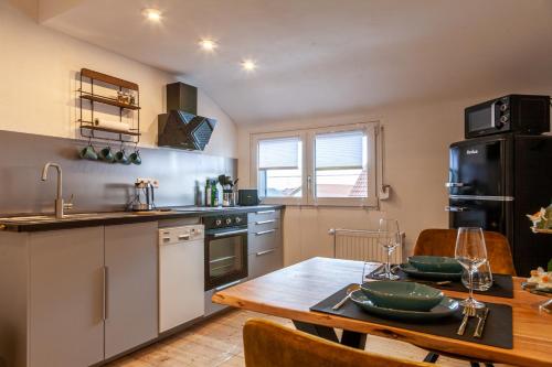 a kitchen with a wooden table and a dining room at nidusROOMS: Art Déco Apartment nähe Heidelberg in Leimen