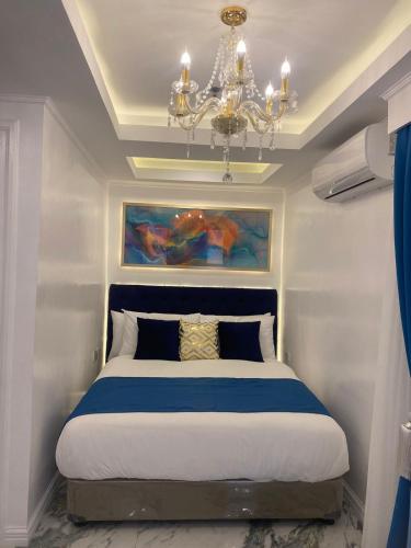 a bedroom with a large bed with a chandelier at MAKATI Isabela Luxury in Manila