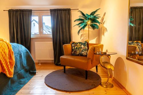 ein Wohnzimmer mit einem Stuhl und einem Fenster in der Unterkunft nidusROOMS: Art Déco Apartment nähe Heidelberg in Leimen