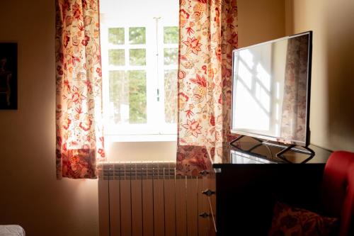 a window with curtains and a radiator in a room at Hotel Rural Quinta do Juncal in Serra de El-Rei