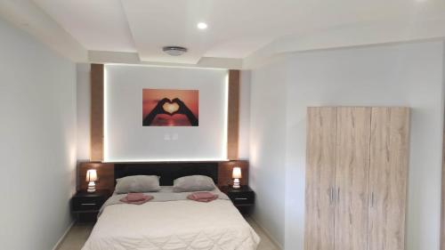 ein Schlafzimmer mit einem Bett und einem Bild an der Wand in der Unterkunft Evelina's studio in Artemida