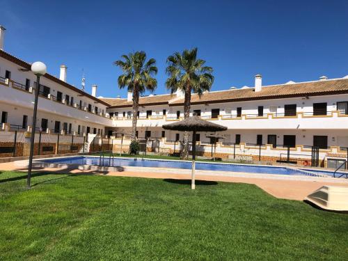 a building with a courtyard with a pool and palm trees at L' Azotea del Sol appartement typique in La Puebla