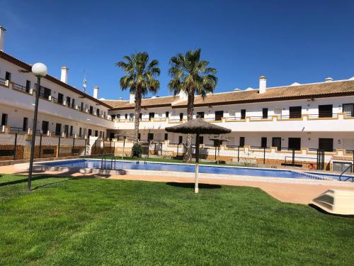 budynek z dziedzińcem z basenem i palmami w obiekcie L' Azotea del Sol appartement typique w mieście La Puebla