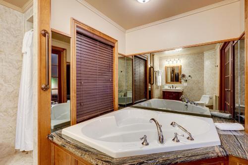 a large bathroom with a tub and a sink at Le Grand Hôtel in Baie-Comeau