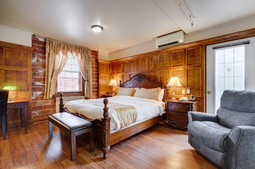 a bedroom with a bed and a couch and a chair at Le Grand Hôtel in Baie-Comeau