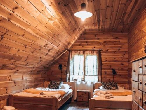 - une chambre avec 2 lits dans une cabane en rondins dans l'établissement Wonderful, atmospheric holiday home in the countryside, Be czna, 