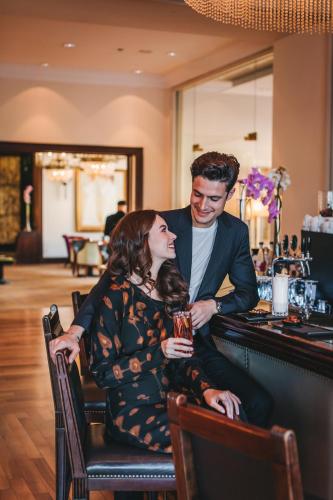 a man and a woman sitting at a bar at Esplanade Zagreb Hotel in Zagreb