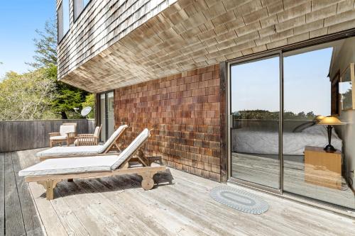 a patio with two lounge chairs on a wooden deck at Sea View in Sea Ranch