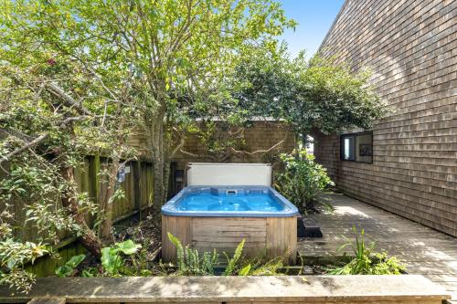 a hot tub in a garden next to a building at Sea View in Sea Ranch
