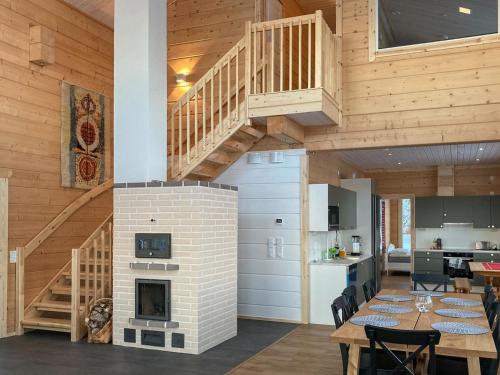 a kitchen and dining room with a fireplace and a staircase at Holiday Home Villa lehtoniemi by Interhome in Sonka