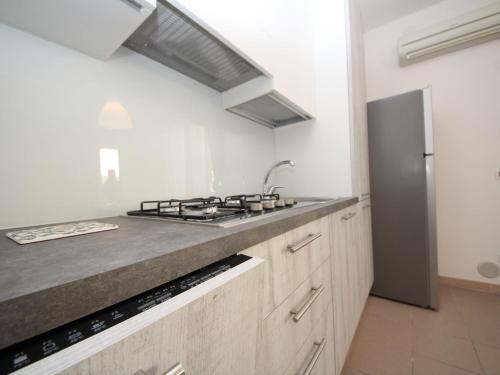 a kitchen with a stove and a sink and a refrigerator at Apartment Veranda by Interhome in Rosapineta