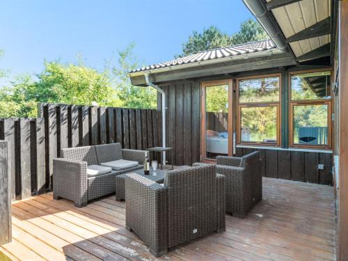 een patio met rieten meubels op een houten terras bij Holiday Home Kali - 900m to the inlet in The Liim Fiord by Interhome in Løgstør