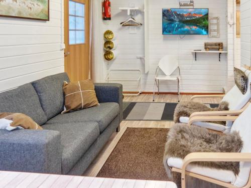 ein Wohnzimmer mit einem Sofa und 2 Stühlen in der Unterkunft Holiday Home Mustalampi 3 lintukoto by Interhome in Niskala