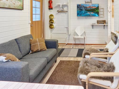 ein Wohnzimmer mit einer Couch und zwei Sesseln in der Unterkunft Holiday Home Mustalampi 3 lintukoto by Interhome in Niskala