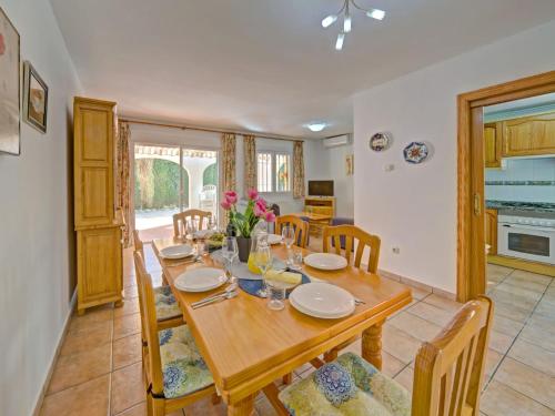 uma sala de jantar com uma mesa de madeira e cadeiras em Holiday Home Res- Puerta de Calpe-3 by Interhome em Calpe