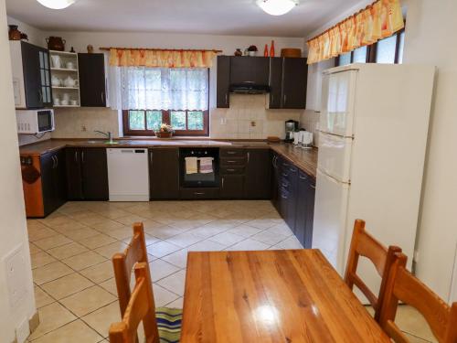 eine Küche mit einem Holztisch und einem weißen Kühlschrank in der Unterkunft Holiday Home Chata Labaika by Interhome in Harrachov