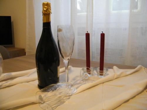a bottle of wine and two wine glasses on a table at Residenza Acqua Terra Fuoco in Como