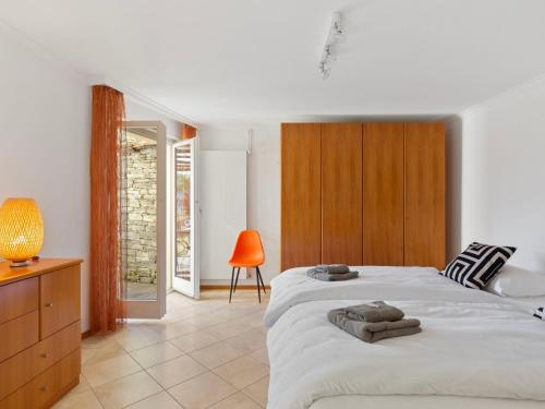 1 dormitorio con 1 cama blanca grande y armario de madera en Apartment Vista Isole di Brissago by Interhome, en Ronco sopra Ascona