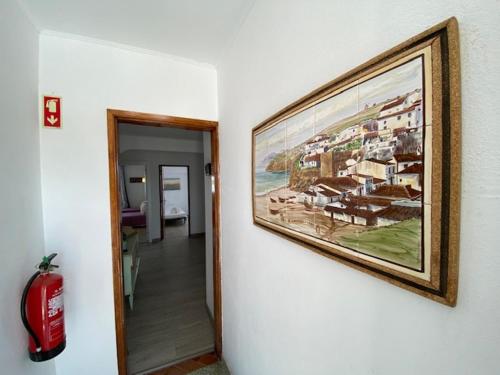 a painting hanging on a wall next to a hallway at Guest House Casa Ramos on the Strip in Albufeira