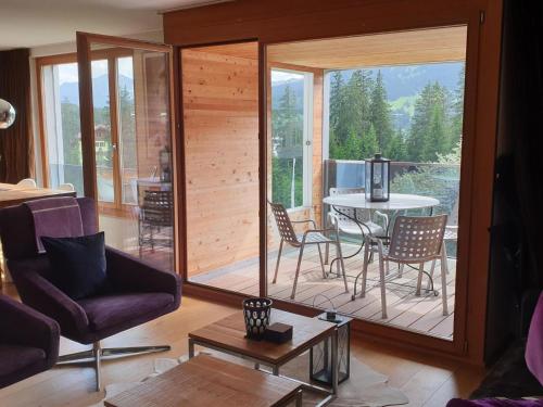 a living room with a balcony with a table and chairs at Apartment Uehlinger Züger by Interhome in Valbella