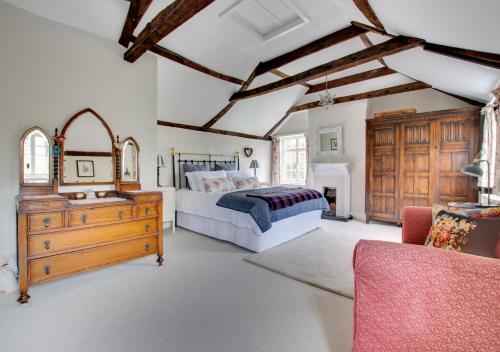 a bedroom with a bed and a wooden dresser at Mill Cottage in Ufford
