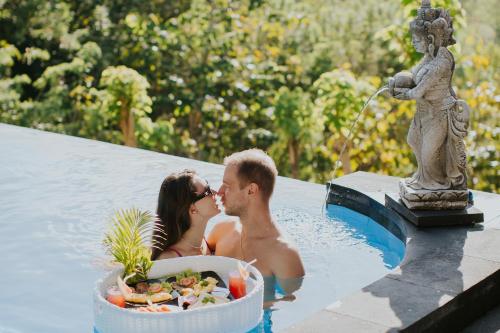a man and a woman kissing in a swimming pool at Abasan Hill Hotel and Spa in Nusa Penida