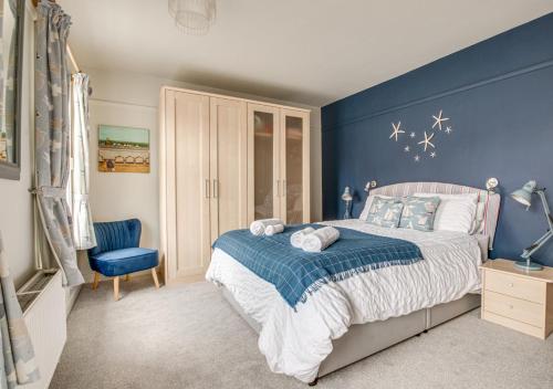 a blue bedroom with a bed and a blue wall at Millers Cottage in Woodbridge