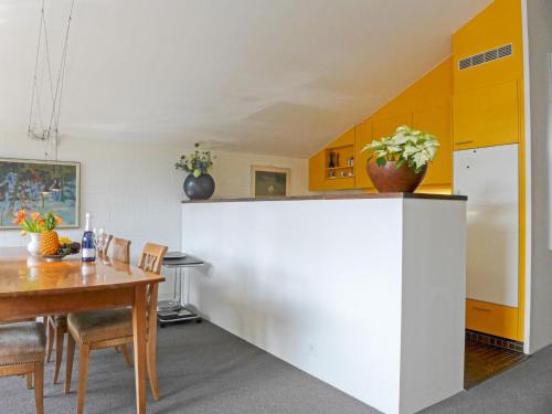 a kitchen with a table and a white counter at Apartment Im Gruebi Apt-5 by Interhome in Wengen