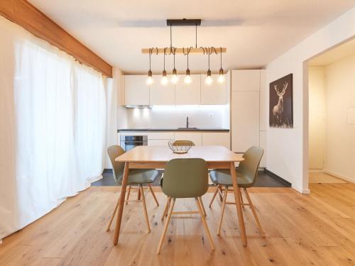 eine Küche und ein Esszimmer mit einem Holztisch und Stühlen in der Unterkunft Apartment Les Mélèzes by Interhome in Les Collons