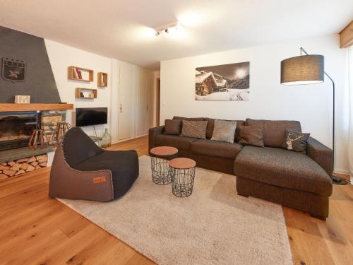 ein Wohnzimmer mit einem Sofa und einem Stuhl in der Unterkunft Apartment Les Mélèzes by Interhome in Les Collons