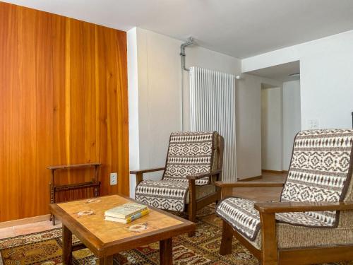 a living room with two chairs and a coffee table at Apartment Della Posta Cervo Giardino by Interhome in Rossa