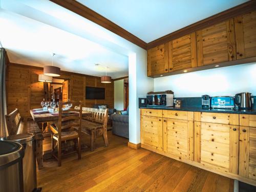 une cuisine avec des placards en bois et une salle à manger dans l'établissement Appartement rénové avec balcon, skis aux pieds, WIFI à Tignes Le Lavachet - FR-1-502-359, à Tignes