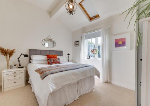 a white bedroom with a large bed and a window at Oak Barn Annexe in Trimley Heath