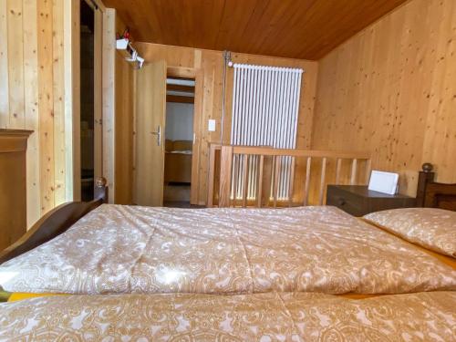 a bedroom with a bed in a wooden room at Apartment Della Posta Stambecco by Interhome in Rossa