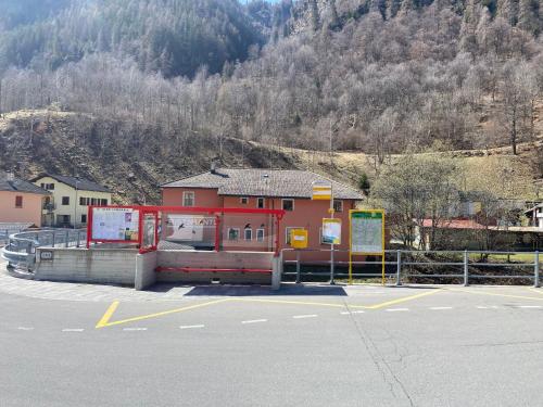 a bus stop in a parking lot next to a mountain at Apartment Della Posta Stambecco by Interhome in Rossa