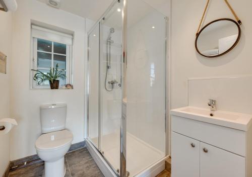 a bathroom with a shower and a toilet and a sink at Oak Barn Annexe in Trimley Heath