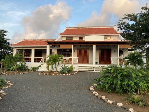 una gran casa blanca con techo rojo en Villa San Sebastian Curaçao en Fontein