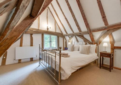 1 dormitorio con 1 cama en una habitación con techos de madera en Old Black Horse Farm, en Finningham