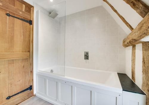 a bathroom with a white bath tub in a room at Old Black Horse Farm in Finningham