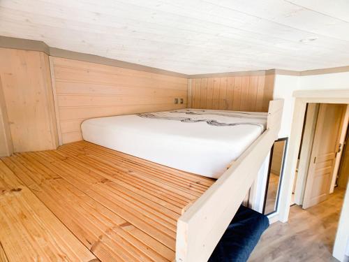 Ce lit se trouve dans une petite chambre dotée de parquet. dans l'établissement Appartement Confortable à Tignes Val Claret - 6 Pers, Proche Pistes, Balcon, Animaux Acceptés - FR-1-502-376, à Tignes
