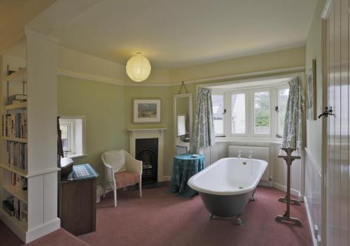 a bathroom with a bath tub and a fireplace at Old Farm in Walberswick