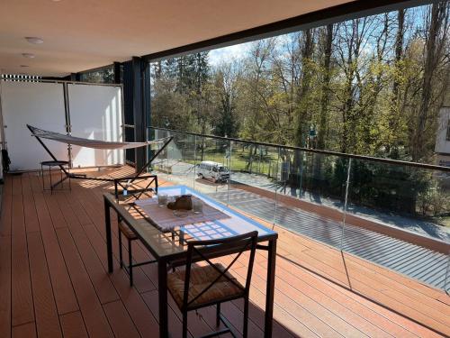 ein Balkon mit Tisch und Stühlen und einem großen Fenster in der Unterkunft Apartment Luxury Sunrise by Interhome in Pörtschach am Wörthersee