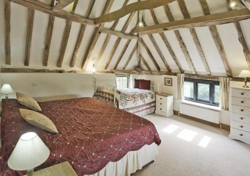 een slaapkamer met een groot bed op zolder bij Owls End at Wattisham Hall in Wattisham