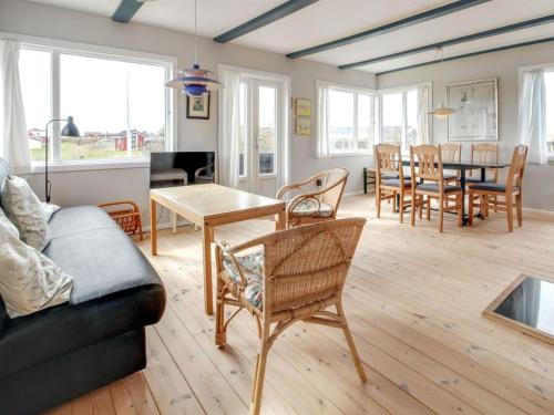 sala de estar con sofá, mesa y sillas en Holiday Home Sohvi - 450m from the sea in Western Jutland by Interhome en Lakolk