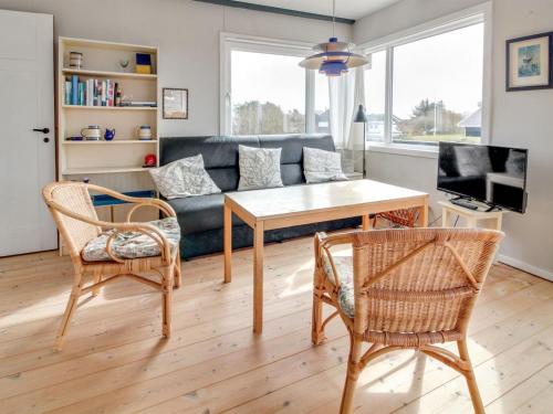 salon z kanapą, stołem i krzesłami w obiekcie Holiday Home Sohvi - 450m from the sea in Western Jutland by Interhome w mieście Lakolk