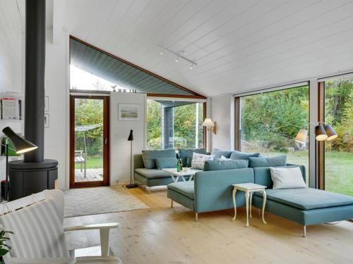 sala de estar con sofá azul y sillas en Holiday Home Aino - 1km from the sea in Sealand by Interhome en Liseleje