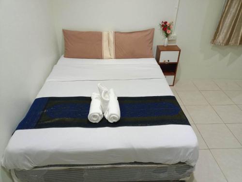 Un dormitorio con una cama con dos zapatos blancos. en Kata S.T House 2 en Phuket