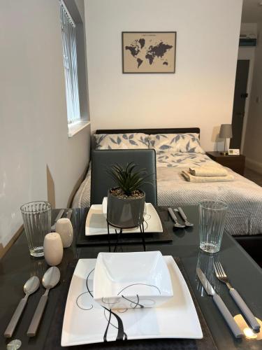 a table with utensils on it with a bed at Apt 3. Private Studio in Moseley, Birmingham in Birmingham