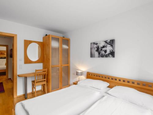 a bedroom with two white beds and a table at Chalet Pflaume by Interhome in Bad Gastein