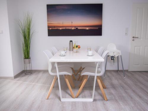 un tavolo da pranzo bianco con sedie in camera di Holiday Home Essen by Interhome a Norddeich